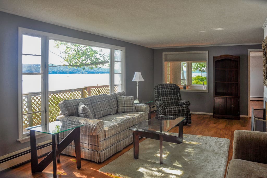 Spacious, waterfront living room with new flooring and large, flat-screen smart TV