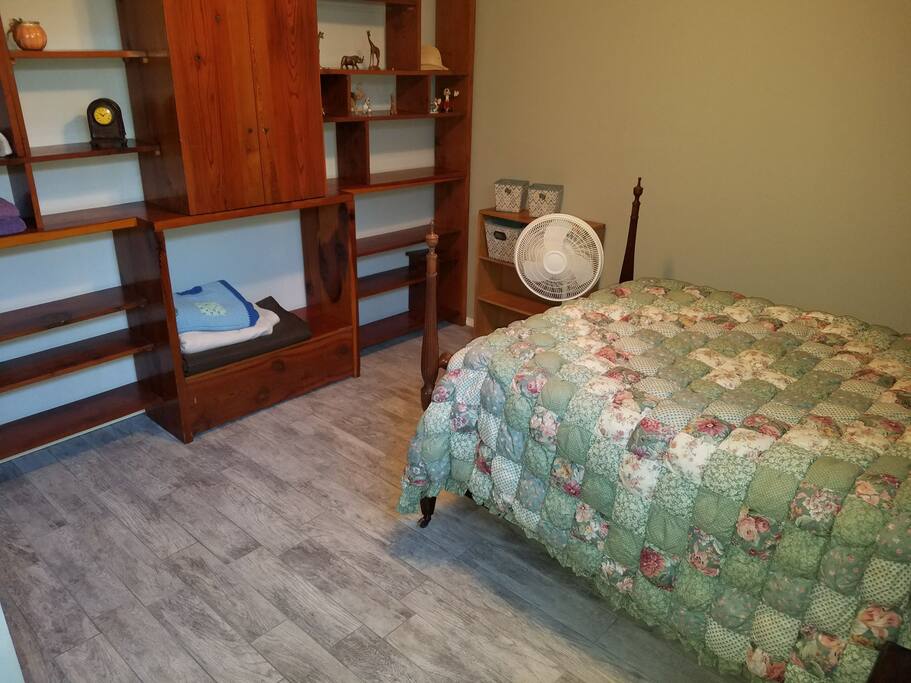 Full size bed, comfortable large room, with tile floor. Shelving unit.