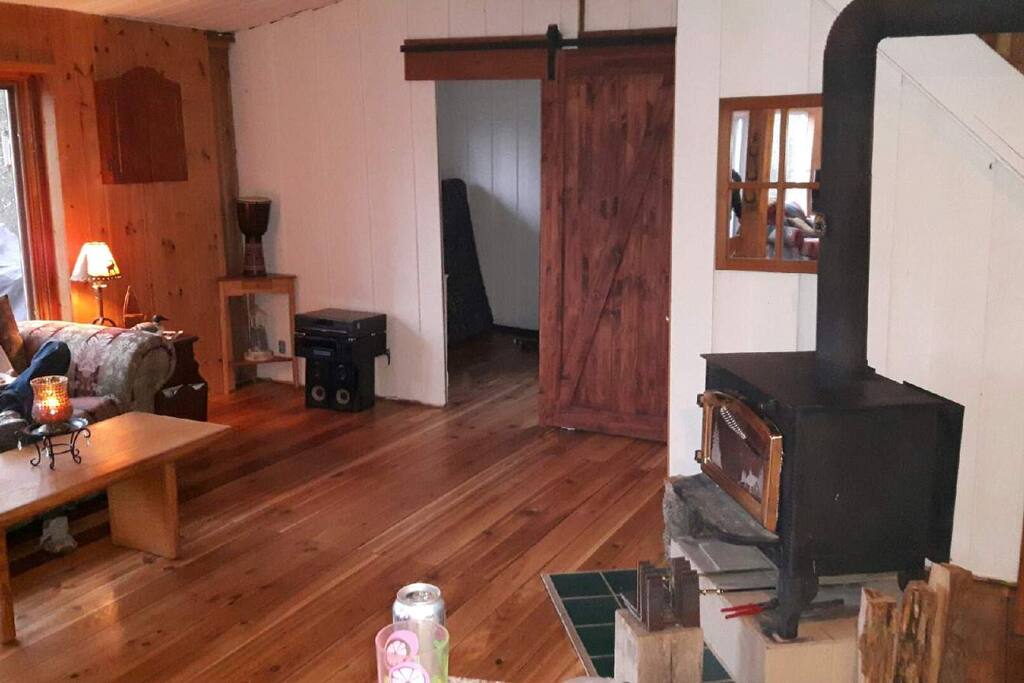 Living room looking onto main floor bedroom with beutiful barn door.