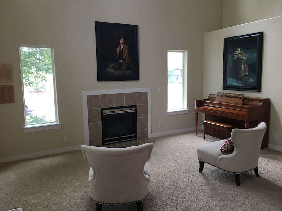 Vaulted entryway room featuring a fireplace and piano. A great place to curl up to a good book.
