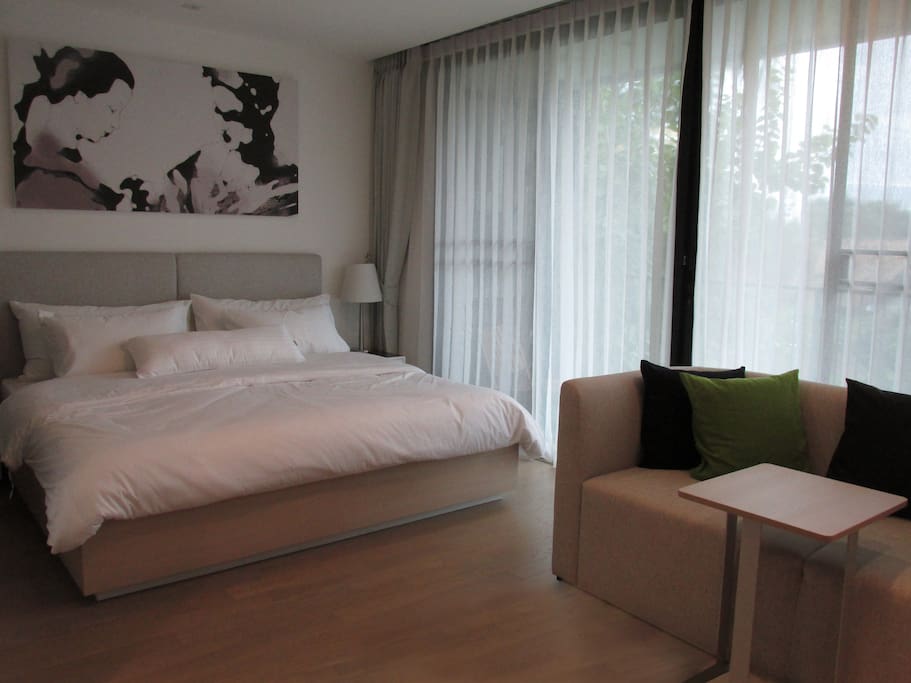 Bedroom with hotel-grade white cotton bed-linens with slidable door to separate from living area when needed