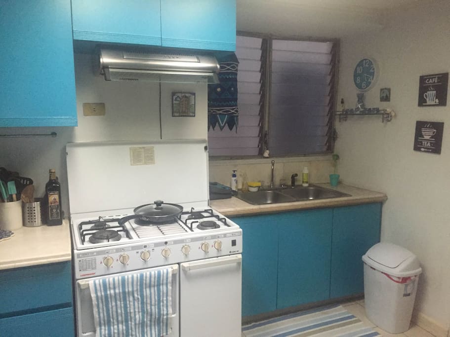 Kitchen complete with microwave, stove and capsule coffee maker.