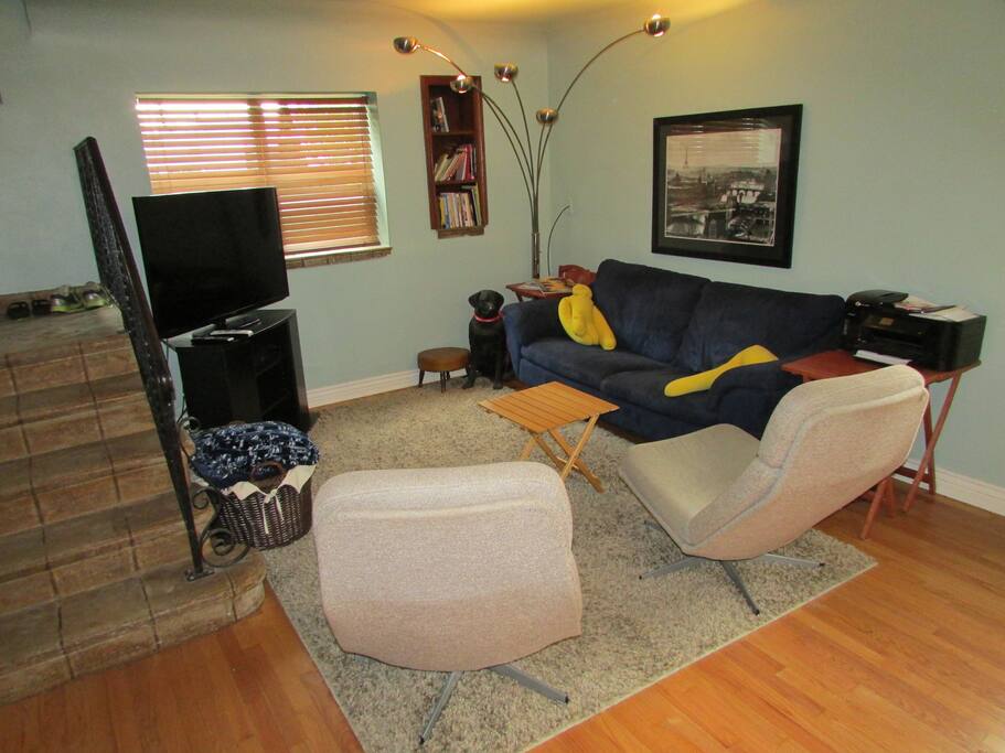 Living area with flat screen, comfy couch and chairs.