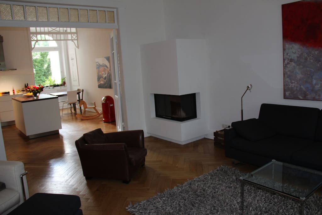 Wohnbereich mit Kamin und Blick auf die offene Küche