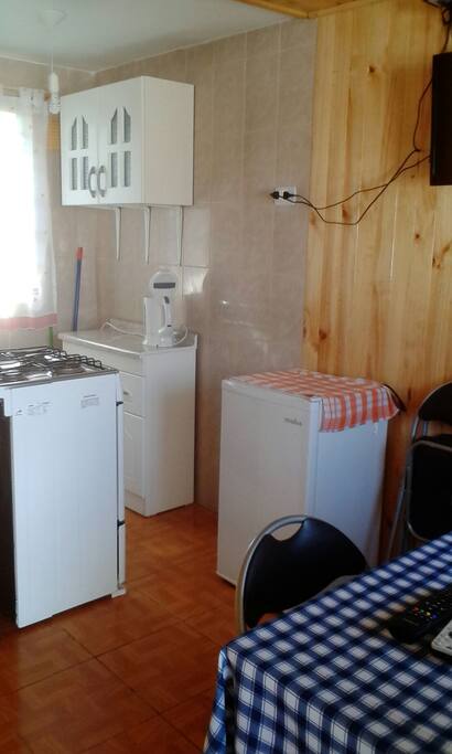 Cocina equipada con hervidor, refrigerador, cocina con horno y calefont.