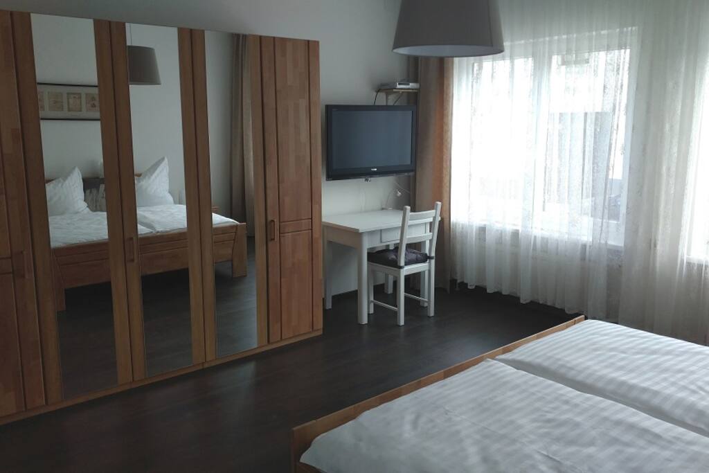 Schlafzimmer mit Schreibtisch und Fernseher