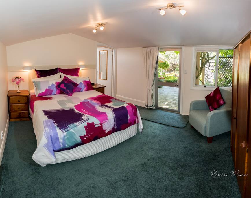Spacious bedroom with second door leading to deck area.