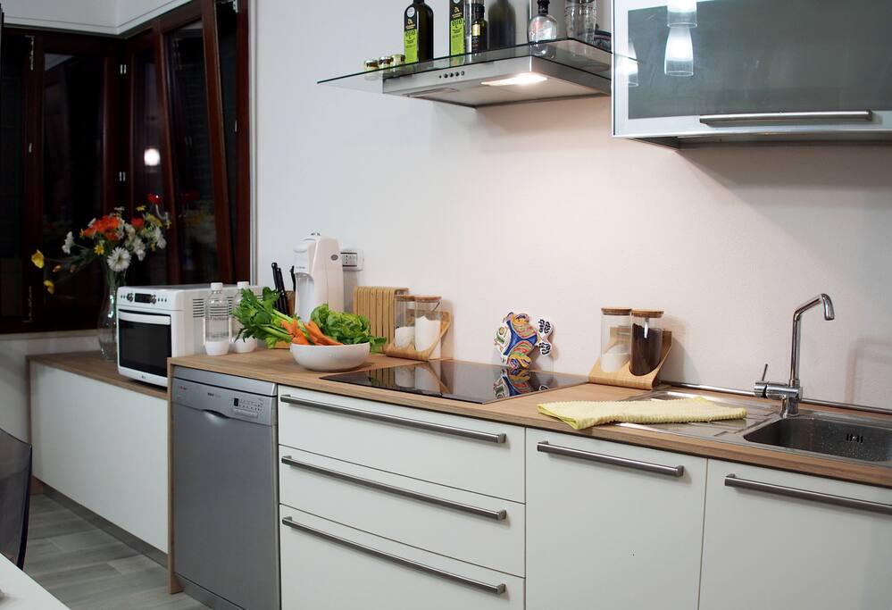 Open kitchen with induction stove, microwave, dishwasher, refrigerator