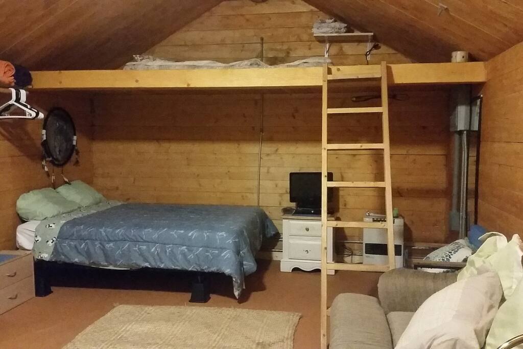 queen bed and tv with stairs for loft