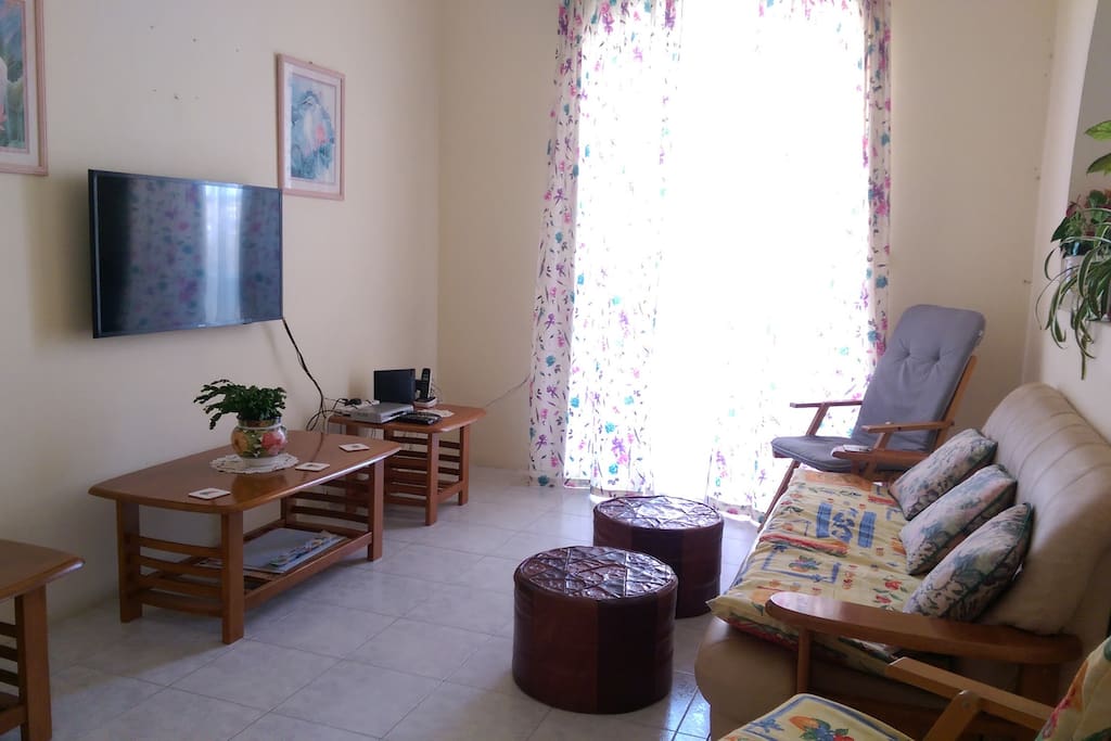 Living area with smart TV leading to balcony with sea view