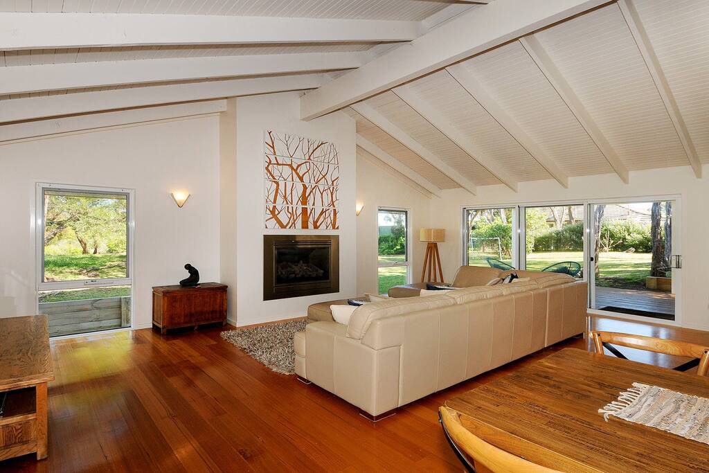 Living room with gas heater and air conditioner leading out to outdoor area