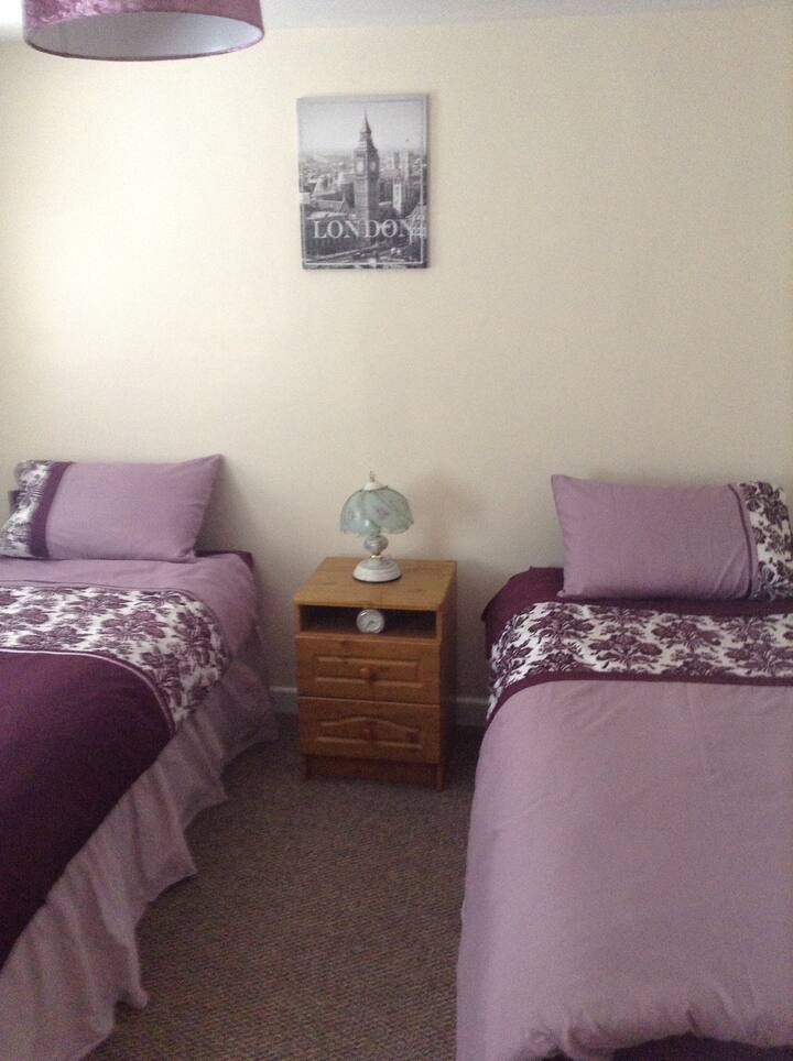 Second room with two single beds. Wardrobe and bedside table. 