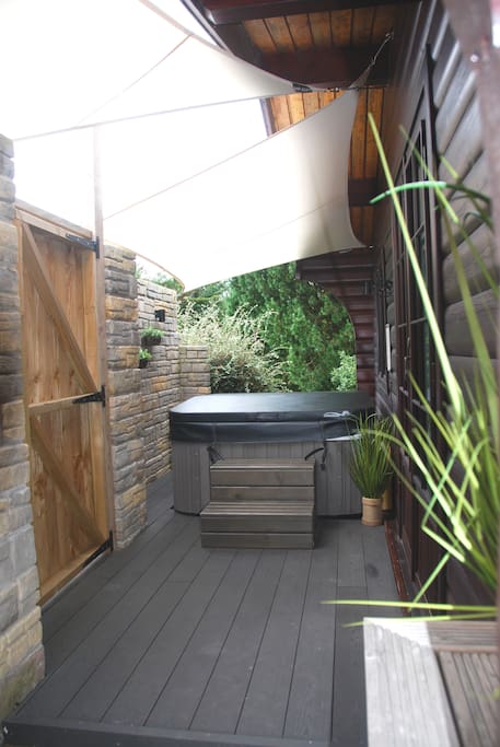 Composite decking, hot tub and sail shades for additional shelter and privacy