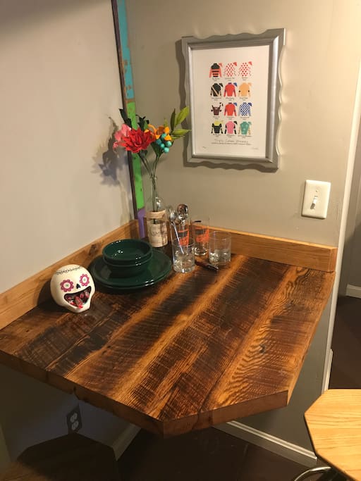Reclaimed barn wood table, two stools, and local artwork