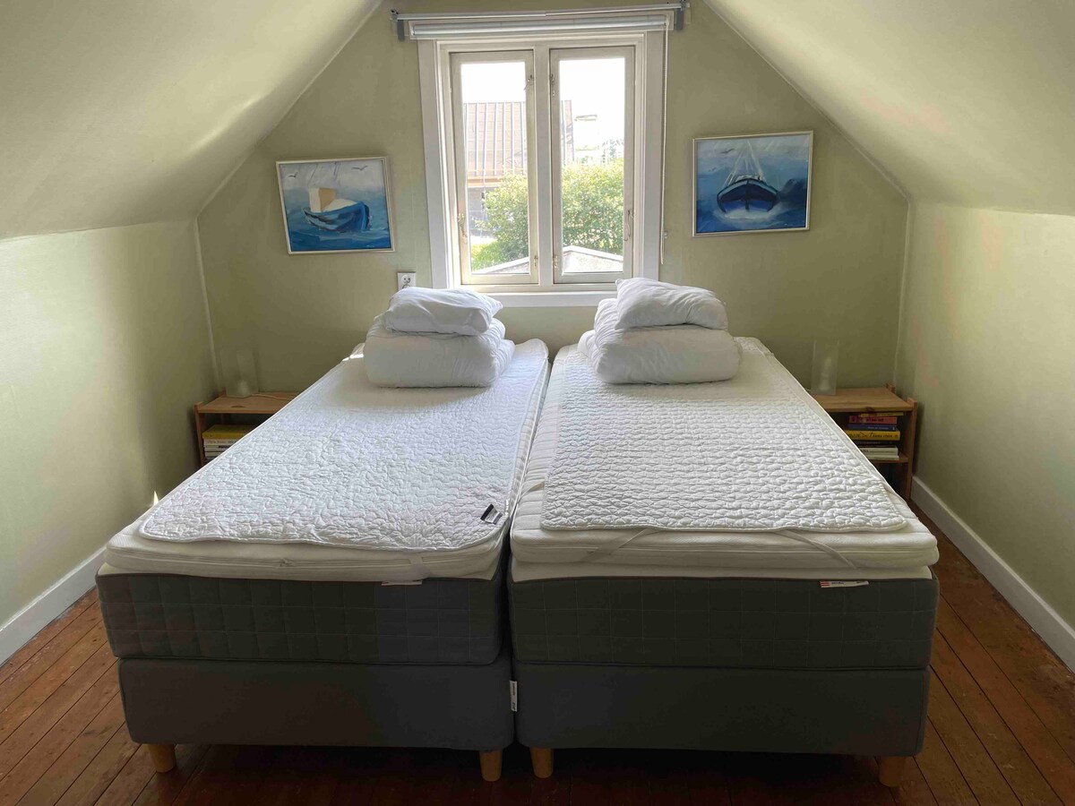 Spálňa s manželskou posteľou (2 samostatné postele) s výhľadom do záhrady.