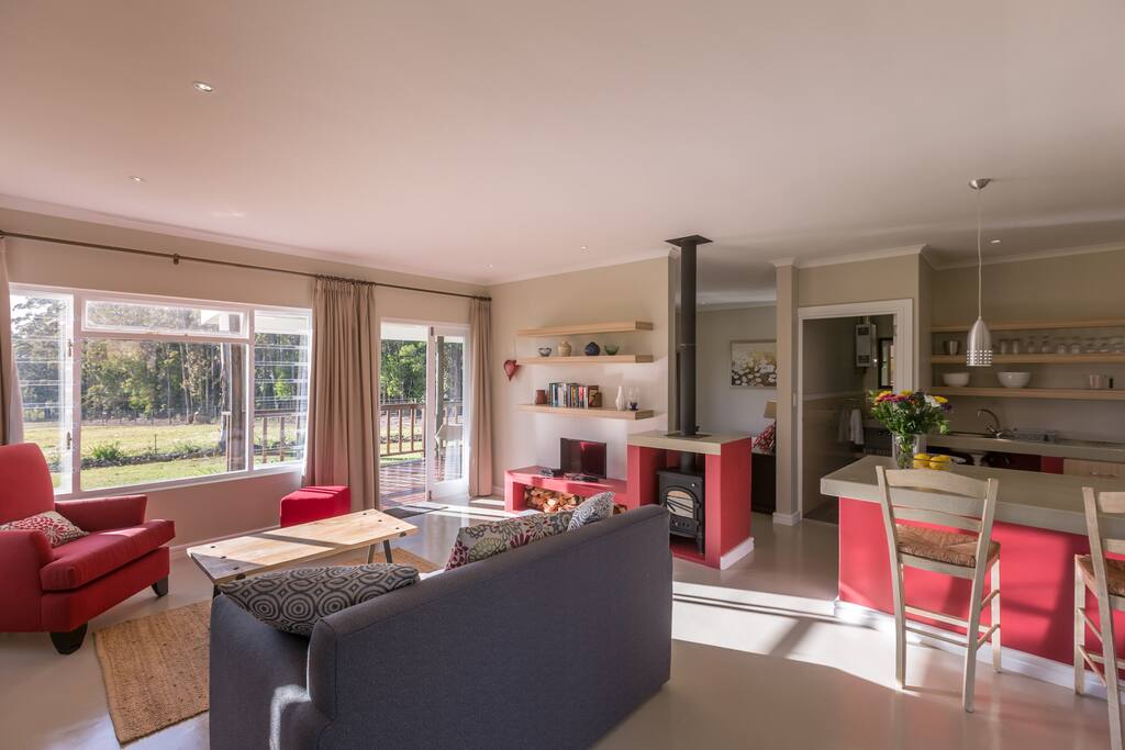 Open plan lounge and kitchen with large windows overlooking the gardens and farm.
