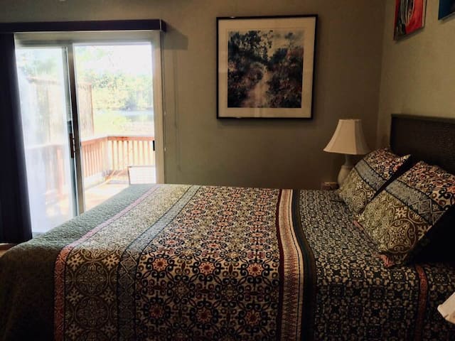 Large bedroom with a lake view and private deck