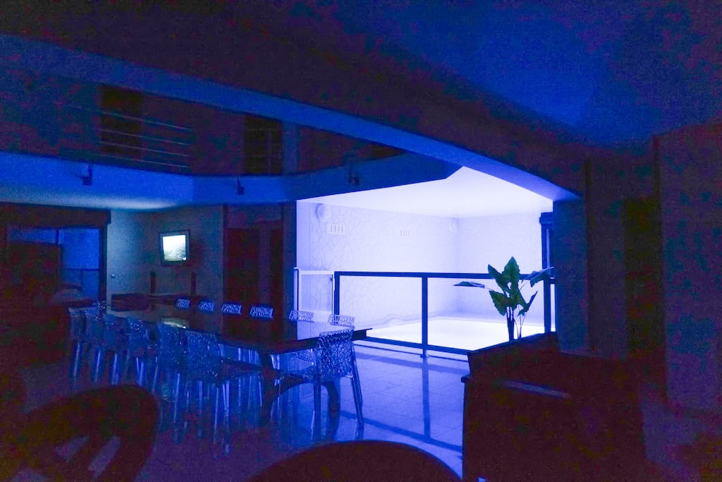 Piscine intérieure dans le salon avec éclairage nocturne