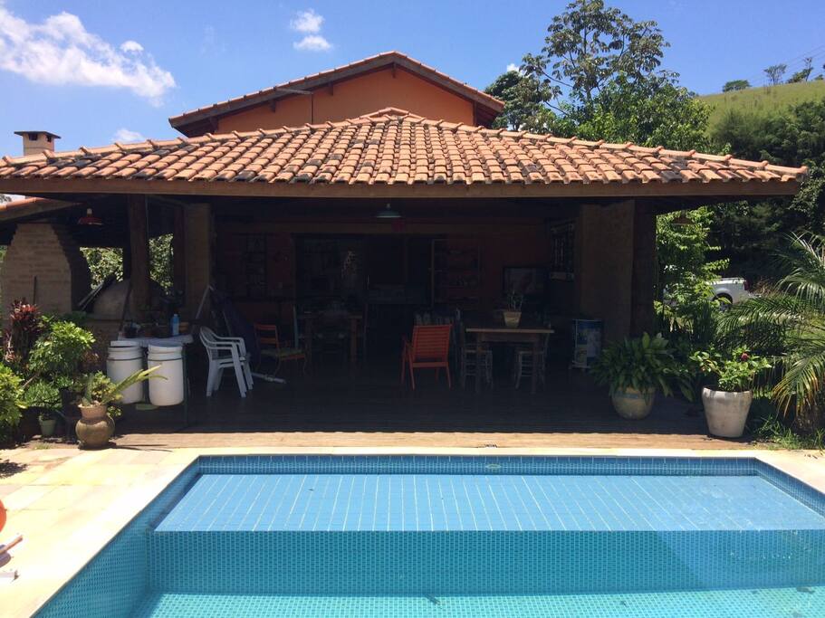 Ampla varanda à beira da piscina, com forno a lenha, churrasqueira, forno de pizza e TV (com Sky)