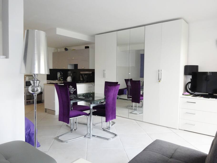 Another view of the lounge with dinning table, TV & chest of drawers