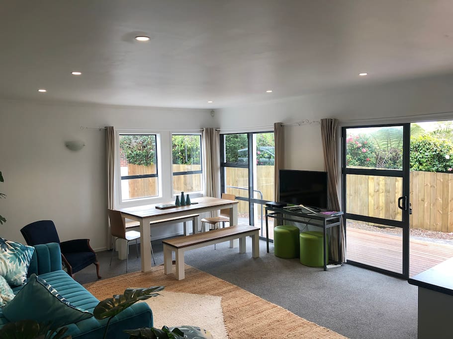 Lounge & dining flow to decks with BBQ, lounger & chairs.