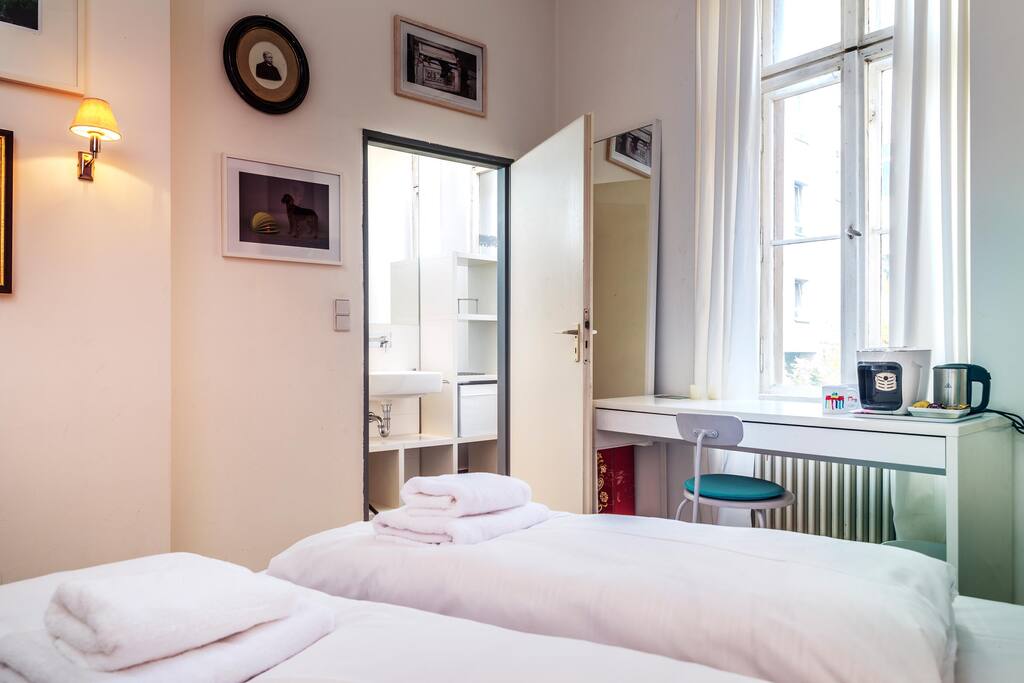 bedroom with fresh linen and towls, desk with coffee maker and water heater