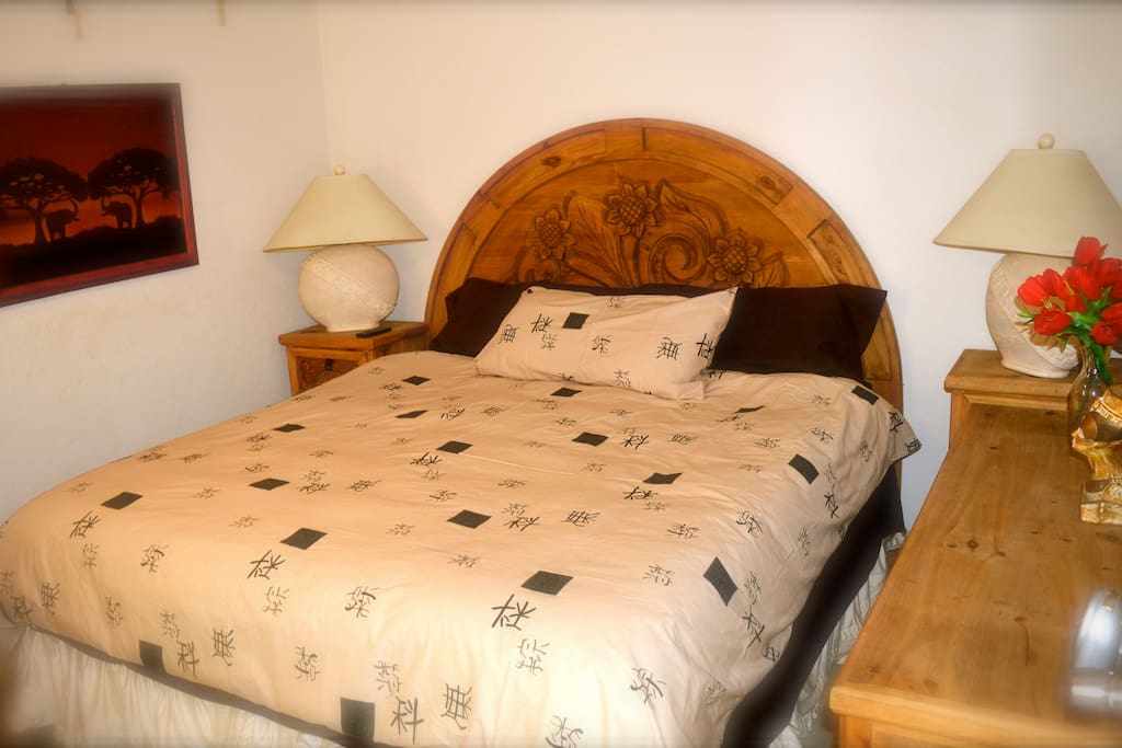 The bedroom with a custom headboard, nightstands and dresser. Hand made here locally in San José. A comfortable bedroom with air conditioning.
