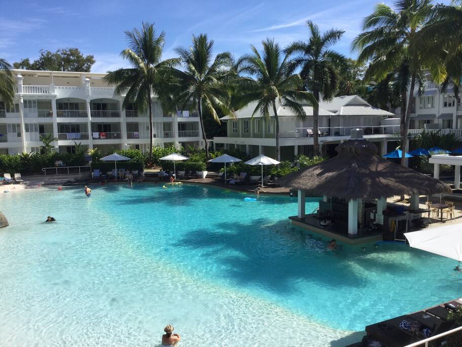 Apartment is on first floor above umbrella to left of Palm tree