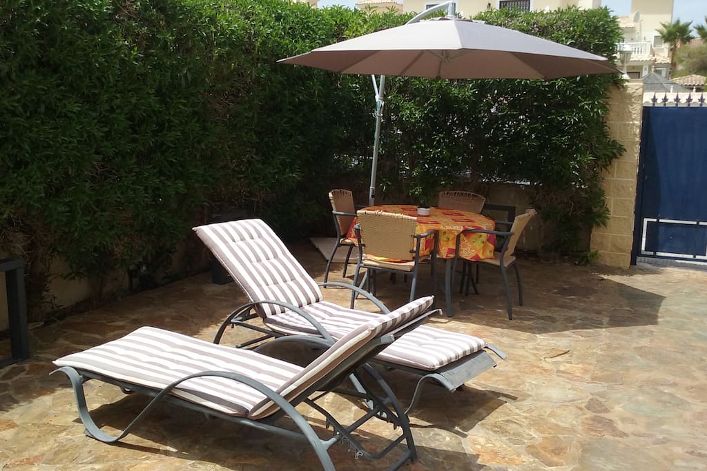 2nd terrace with dining table, umbrella and sun beds