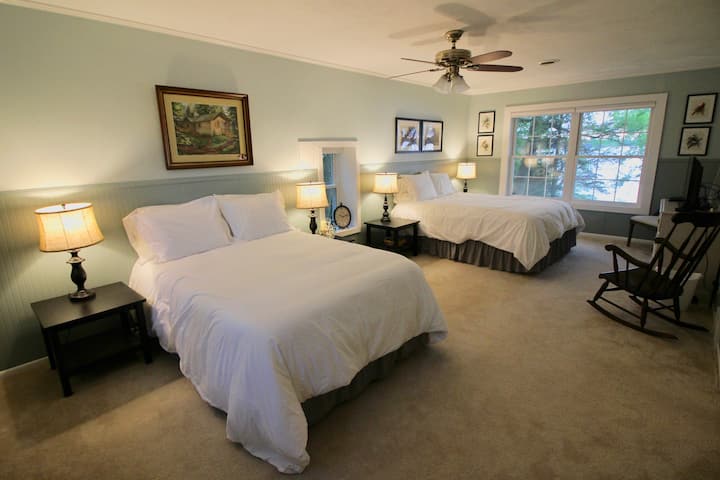 The spacious master bedroom boasts one queen and one full size bed and stunning lake views