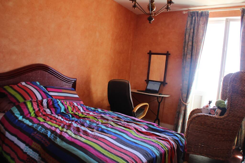 the double-bed and desk behind it, with access to the terrace