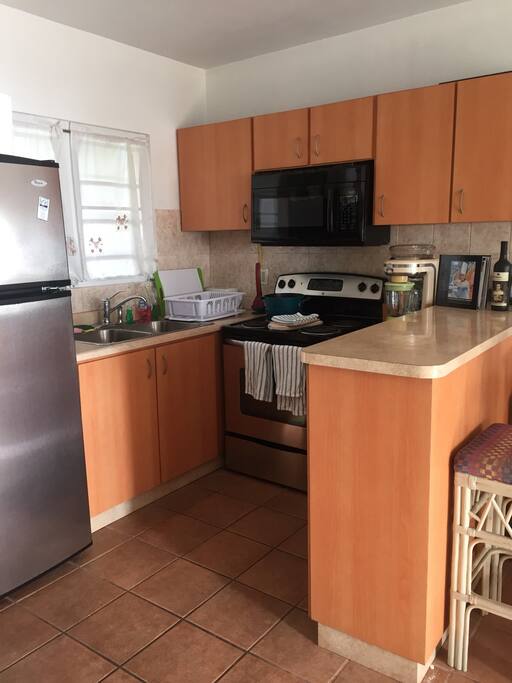 Kitchen with full size fridge, oven, microwave, toaster oven, pots and pans, plus other cooking essentials