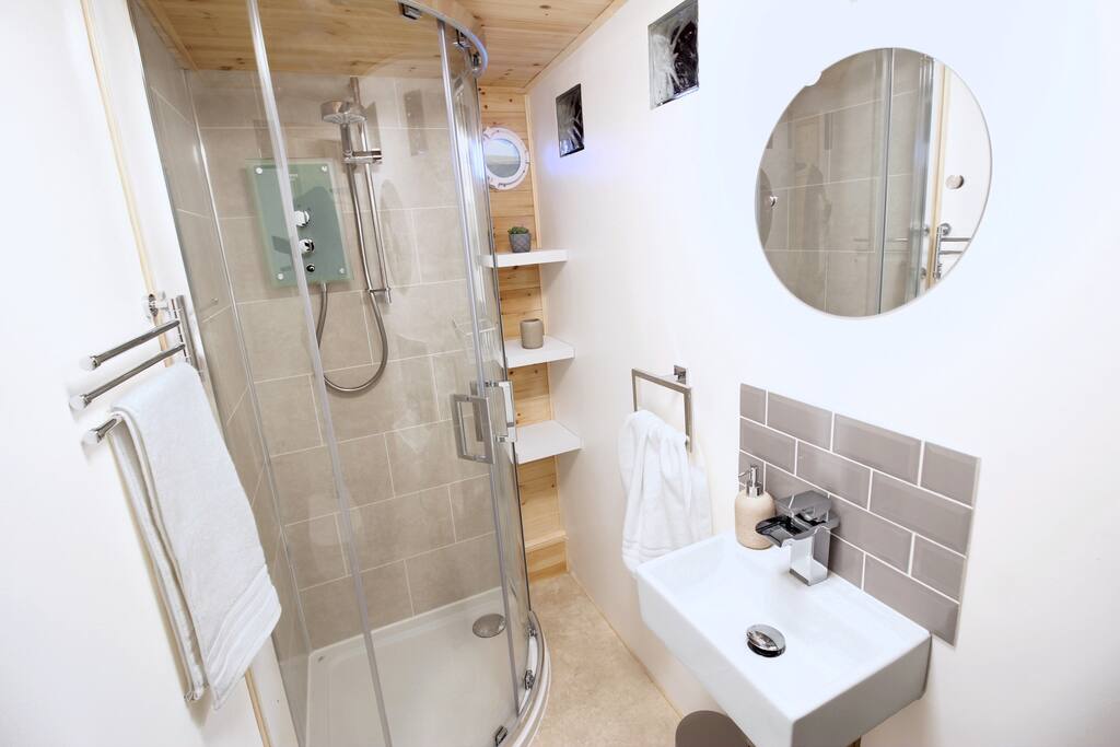 Mira Quadrant Shower next to shelving and charming porthole