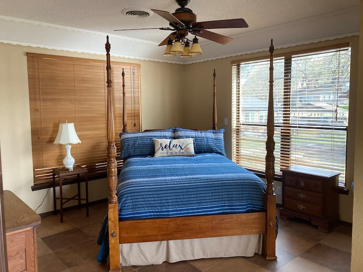 חדר שינה ראשי עם מיטת קווין סייז וחדר רחצה נפתח אל הדק. 