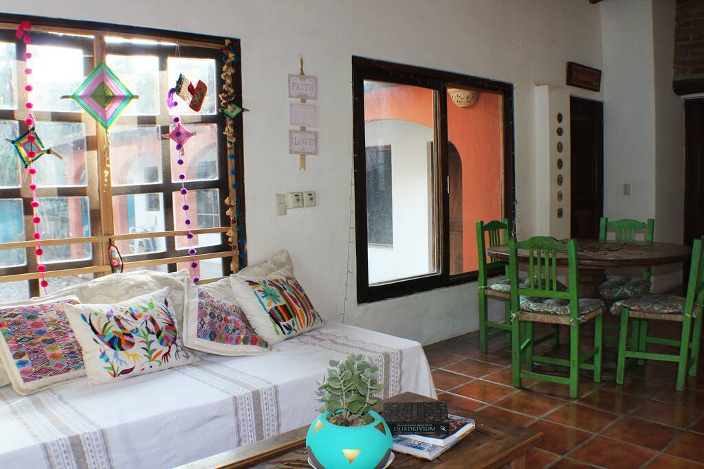 Living room area + beautiful carved wooden kitchen table.