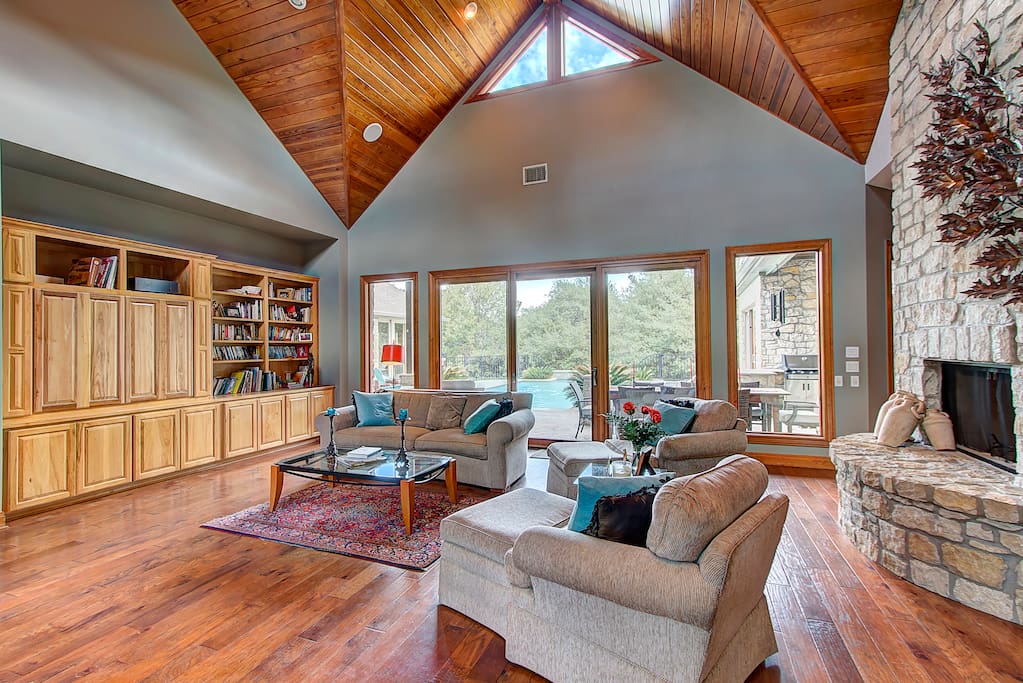 The artisan cathedral ceiling in this spacious living room is impressive yet warm and inviting with open views of the crystal pool and Hillcountry acerage beyond.