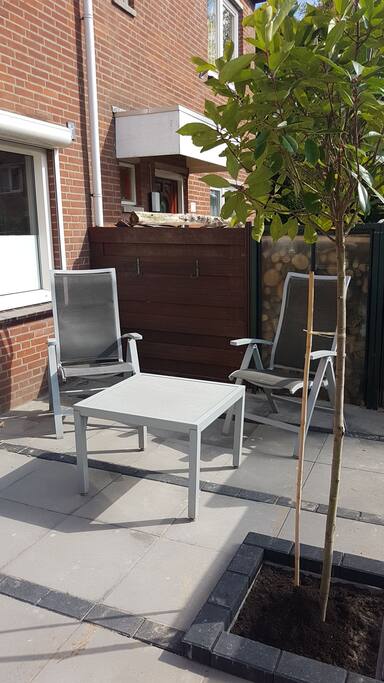 In onze gedeeltelijk afgeschermde voortuin kunt u ook buiten wat relaxen