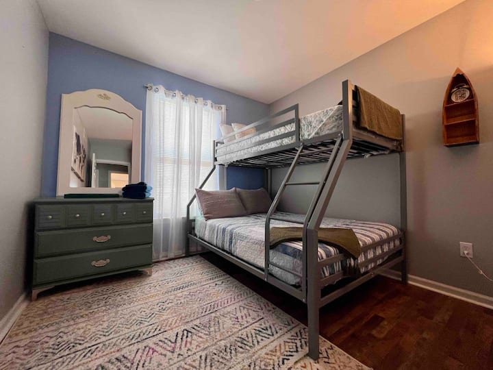 Dormitorio para niños con litera, completo en la parte inferior y doble en la parte superior.  Libros para niños disponibles para los más pequeños.