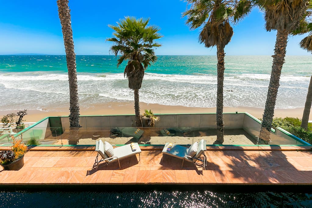 Breezy coast, sand area below the top deck, clear blue ocean and skys.