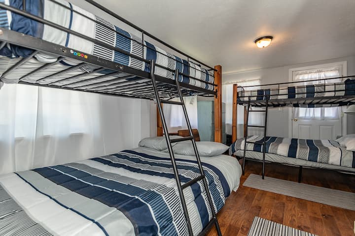 Спалня надолу по стълбите с двуетажни легла, двойно дъно и две единични легла. Директен достъп до банята на долния етаж.