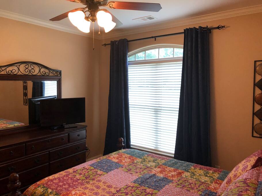 Tv and blackout drapes in queen bedroom.