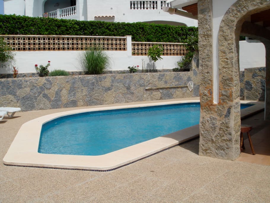 Piscina privada con area de solarium y una terraza cubierta