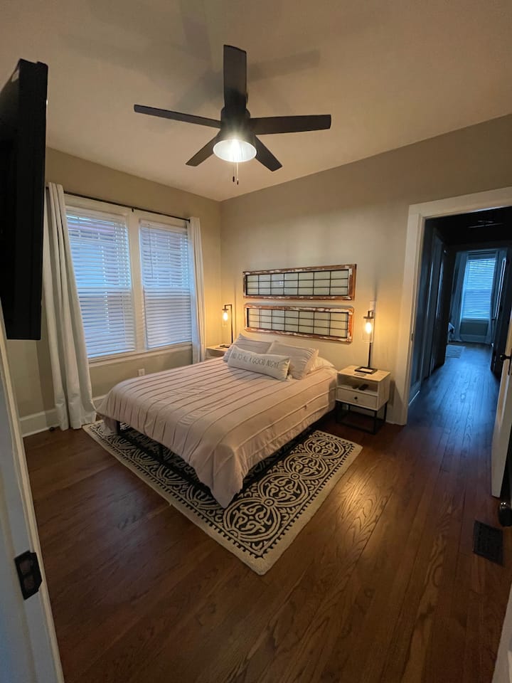 Step out of bed onto a warm and stylish rug. The headboard features windows original to the home.