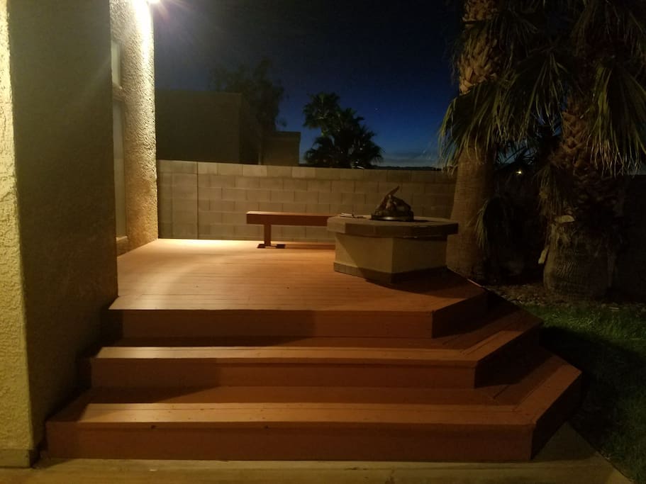 Custom built backyard deck with built in fire pit connected to gas