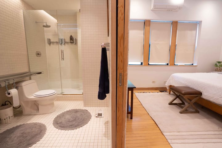 Baño en la planta superior con ducha y cama de invitados al estilo king. Aire acondicionado mini-split con bomba de calor. Puertas de bolsillo personalizadas para privacidad.