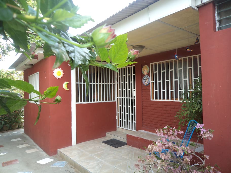 Entrada principal a la casa rodeada de plantas naturales y un espacio para leer y disfrutar de la vista de la ciudad.