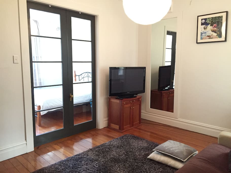Living area, french doors through to bedroom.