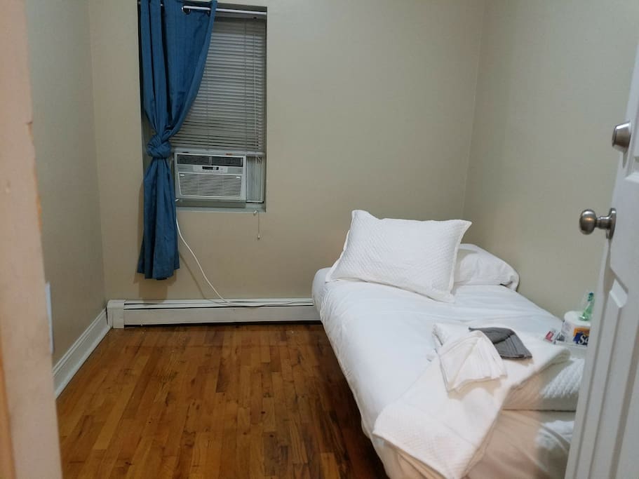 Full size comfortable bed with hard wood flooring