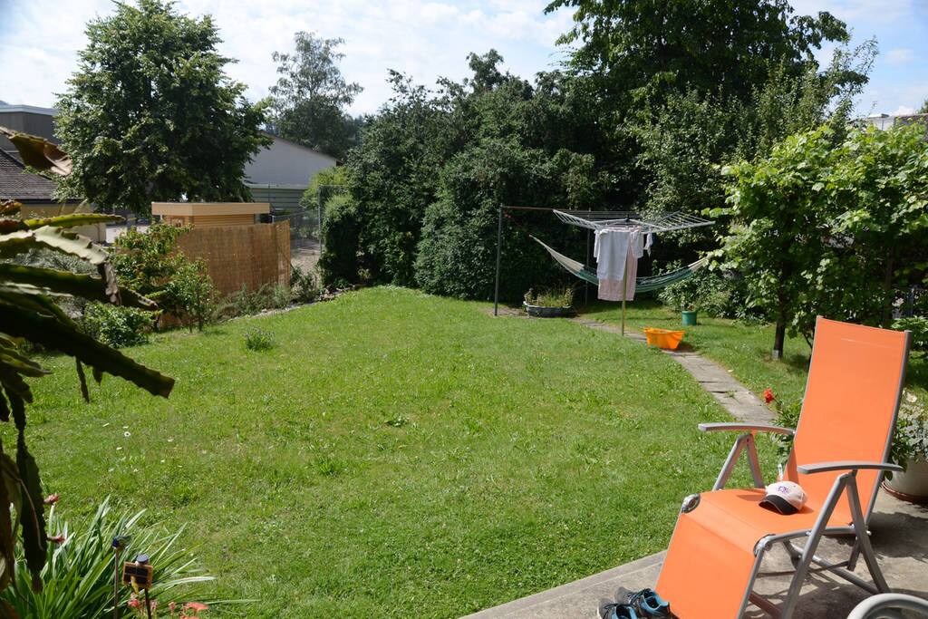 sonniger Garten, mit Blumen und Bäumen: zum Geniessen ist und Badmintonspiel oder im Zelt zu übernachten(Kinder)
