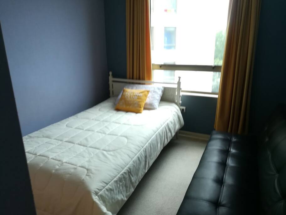 Dormitorio con cama de plaza y media y sofá cama